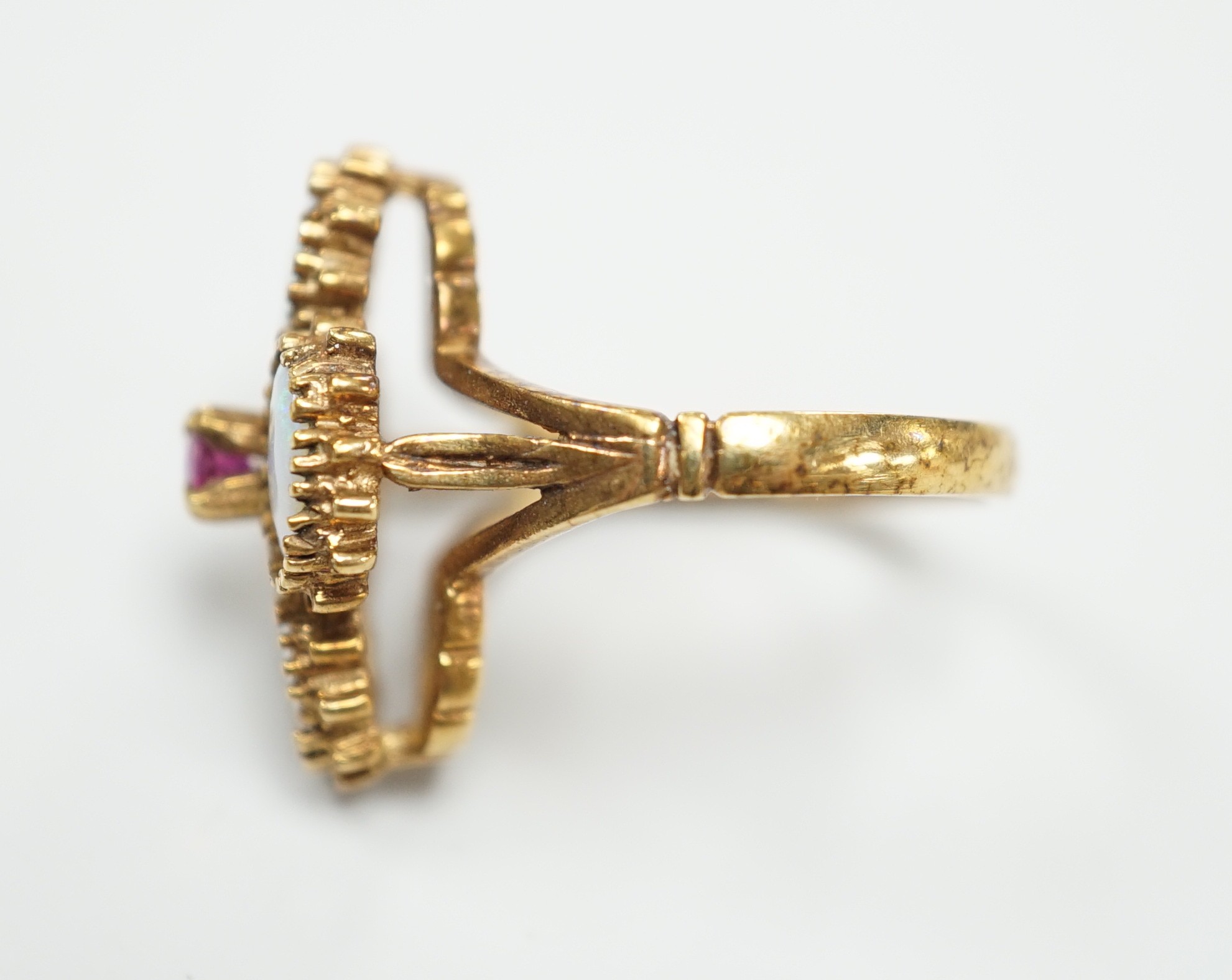 A 1970's 9ct gold, four stone white opal and single stone ruby cluster set dress ring, size O, gross weight 5.2 grams.
